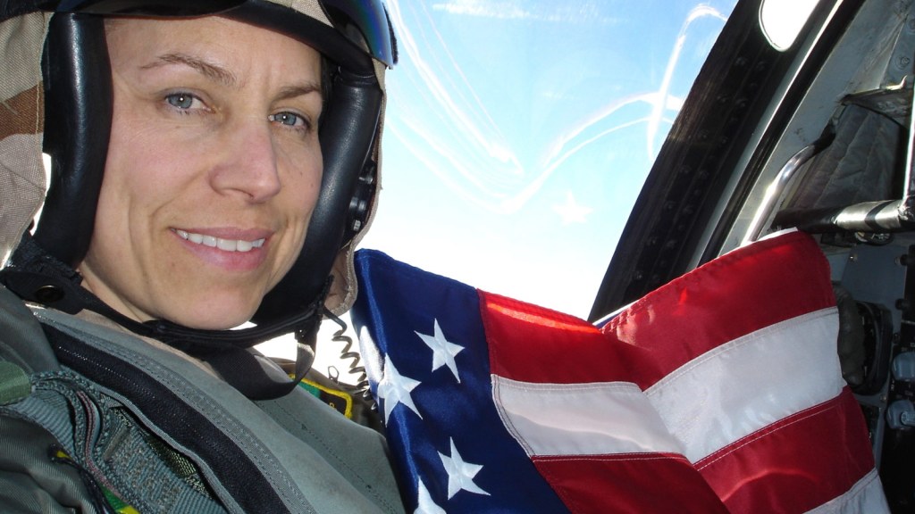 白人女战斗机飞行员举着旗帜