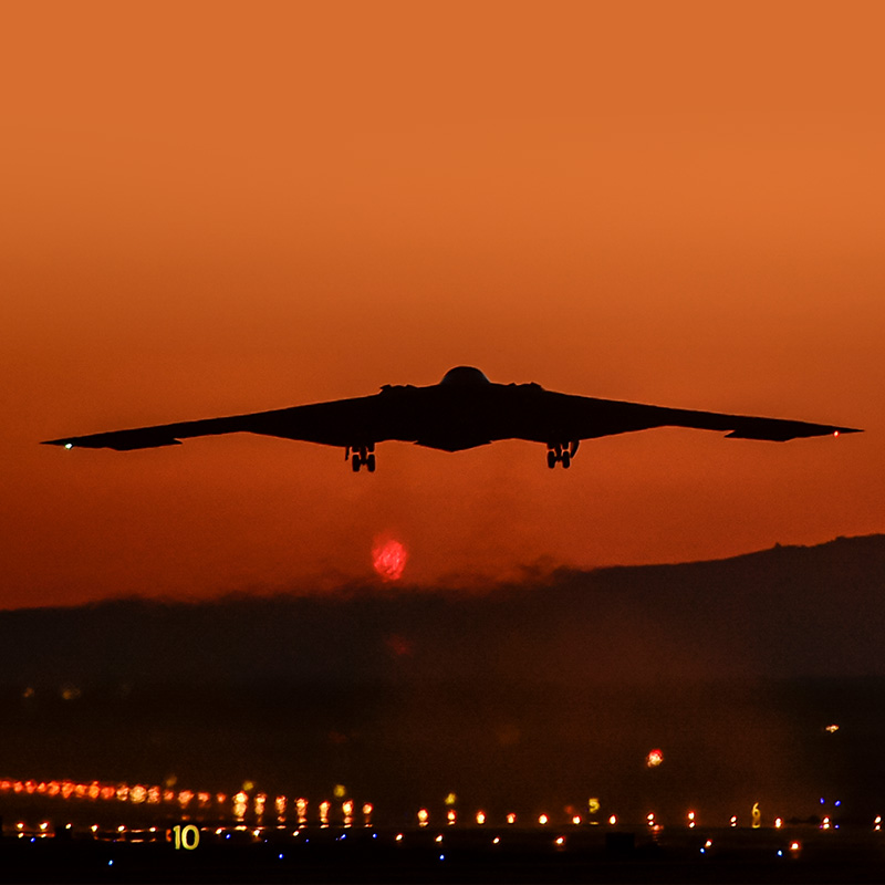 B-2轰炸机在日落时飞向红色的天空